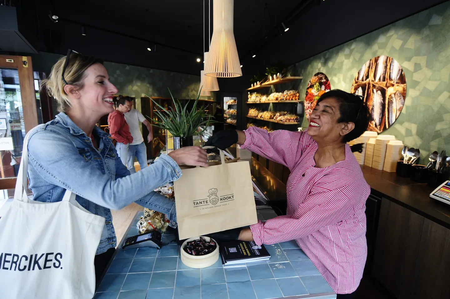 Een klant krijgt een Tante Kookt tas aangereikt in de winkel in Middelburg